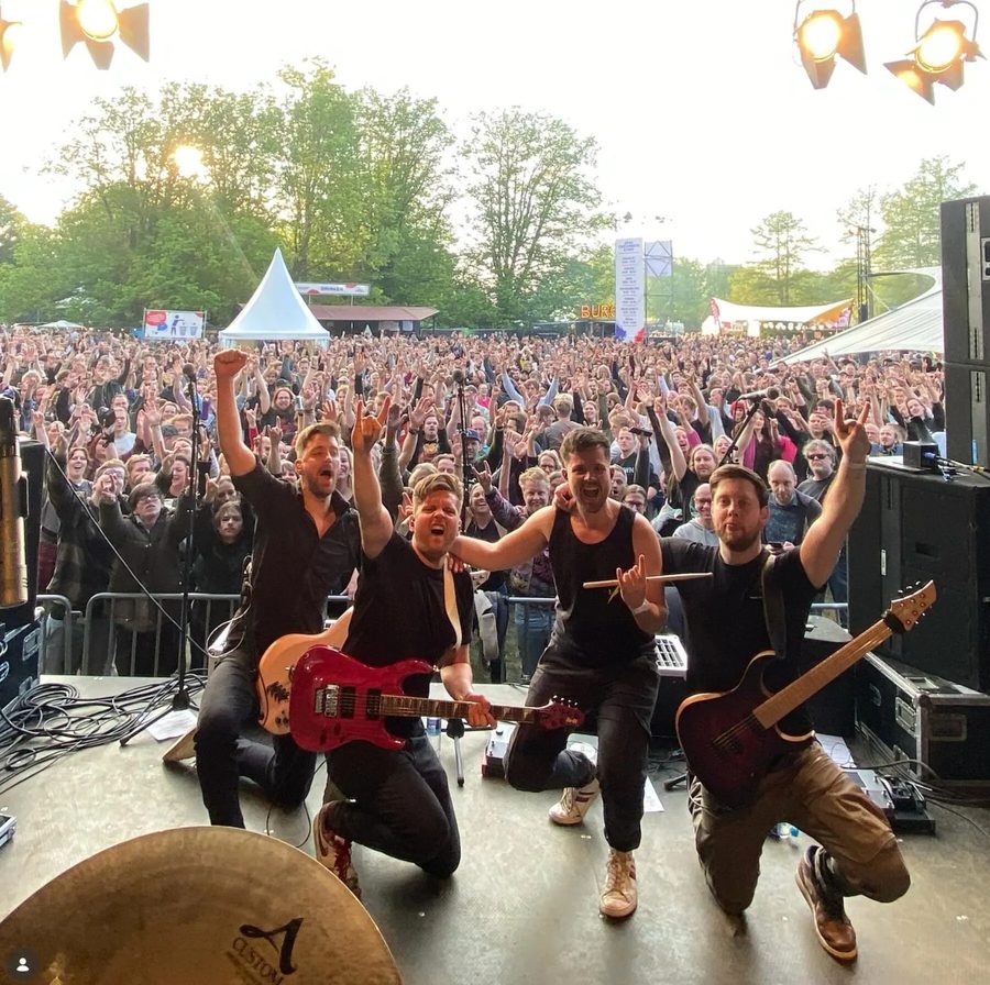 Tom en Michiel met hun metalband op het podium voor een volle festivaltent